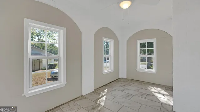 a view of an empty room with windows and closet