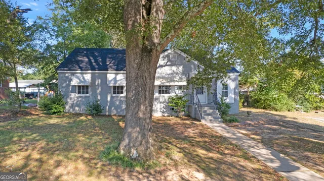a tree in front of a white house