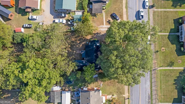 an aerial view of residential houses with outdoor space and trees