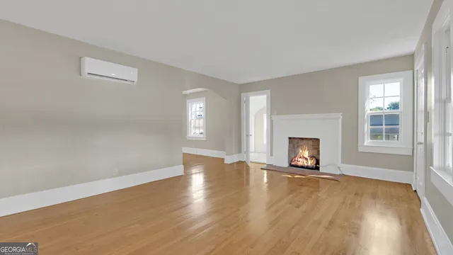 a view of an empty room with a fireplace and a window