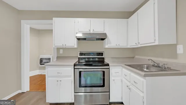 a kitchen with granite countertop white cabinets and white appliances