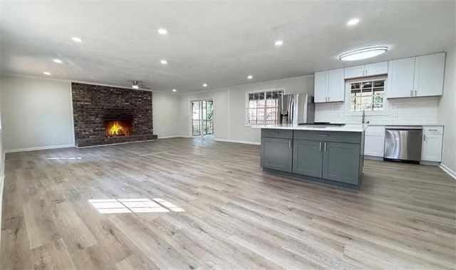 a large kitchen with stainless steel appliances granite countertop a stove a sink and a wooden floors