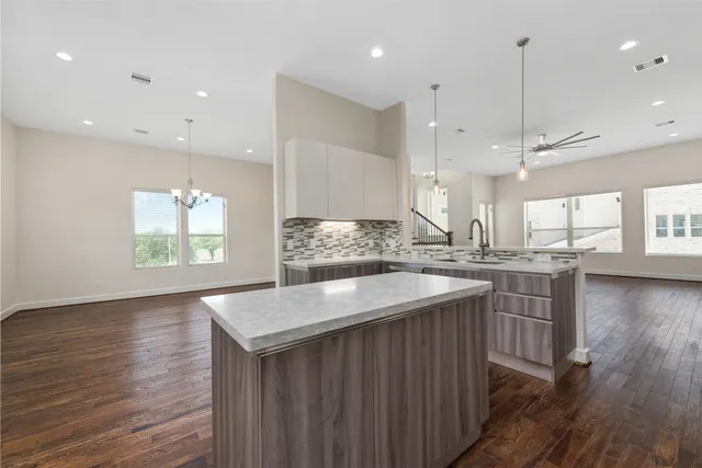 a kitchen with kitchen island a sink appliances and wooden floor