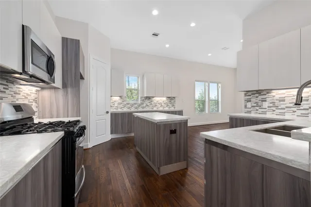 a kitchen with stainless steel appliances granite countertop a sink stove and refrigerator