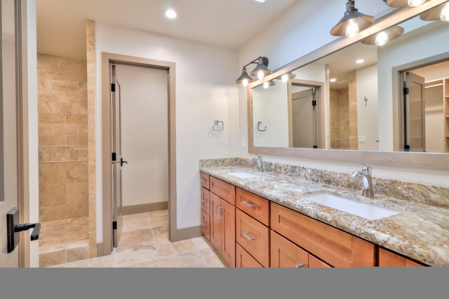 11551 Hidden Valley Road Carmel Valley, CA 93924 - Photo 20 of 33 a bathroom with a granite countertop sink and a mirror