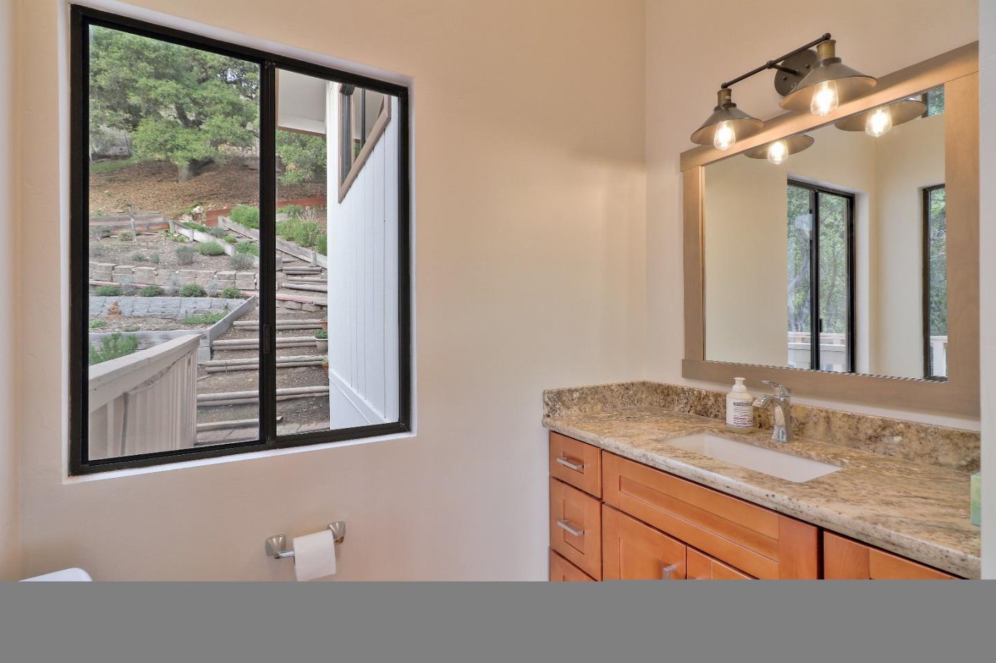 11551 Hidden Valley Road Carmel Valley, CA 93924 - Photo 27 of 33 a bathroom with a granite countertop sink mirror and window