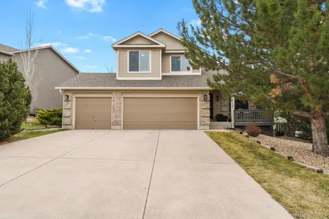 a front view of a house with garage and parking