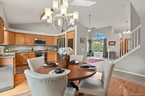 a dining room with furniture a kitchen view and a chandelier