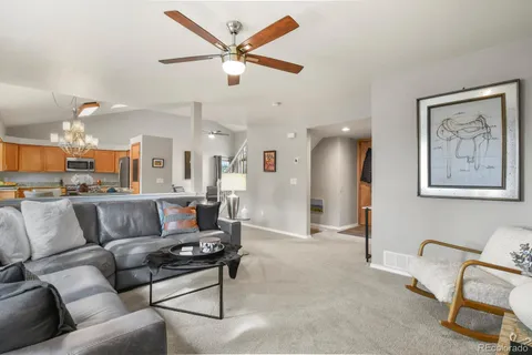 a living room with furniture and a view of kitchen