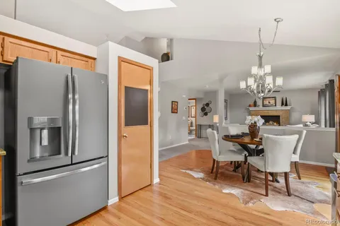 a view of a dining room with furniture a chandelier and wooden floor