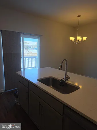 a kitchen with a sink and chandelier