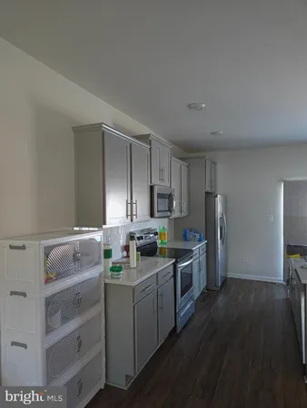 a kitchen with a sink cabinets and wooden floor