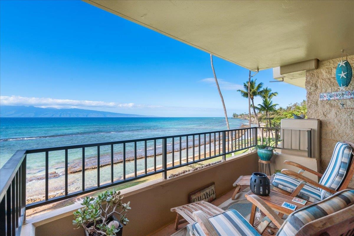 3601 Lower Honoapiilani Road, Unit 201 Lahaina, HI 96761 - Photo 14 of 37 a balcony with wooden floor table and chairs