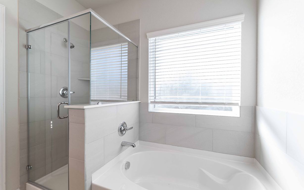 224 Denali Drive Kyle, TX 78640 - Photo 17 of 18 a bathroom with a bathtub a shower and a window