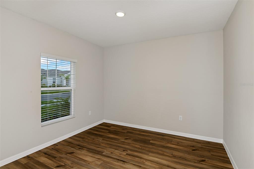4385 Prairie Run Haines City, FL 33844 - Photo 11 of 25 a view of an empty room with wooden floor and a window