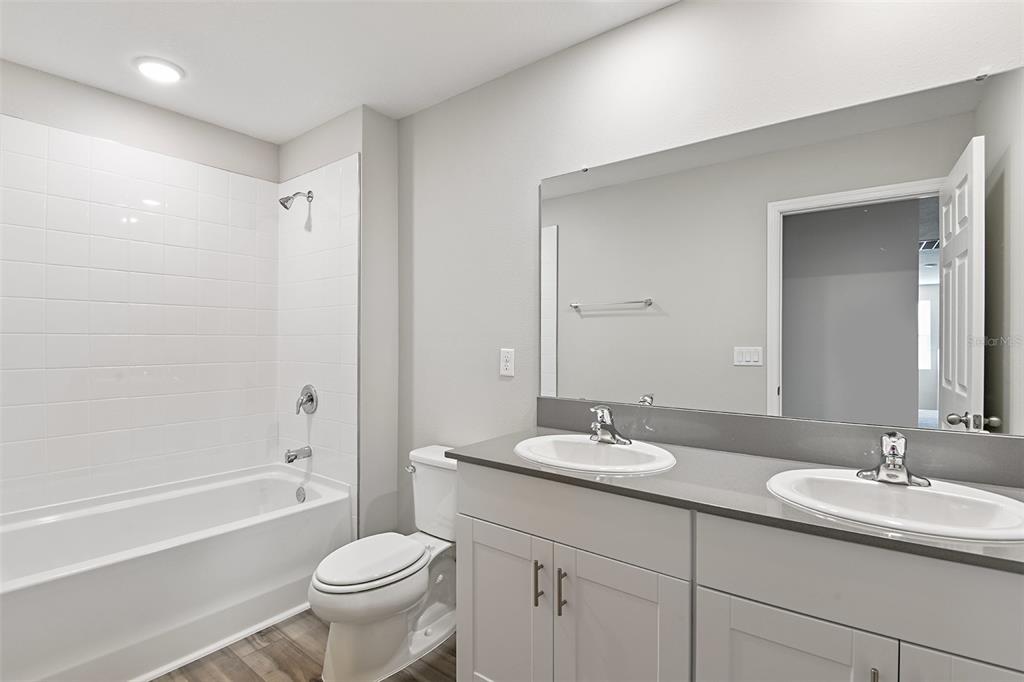 4385 Prairie Run Haines City, FL 33844 - Photo 24 of 25 a bathroom with a double vanity sink toilet and a bathtub