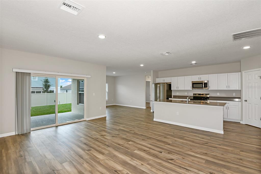 4385 Prairie Run Haines City, FL 33844 - Photo 6 of 25 a kitchen with stainless steel appliances granite countertop a refrigerator and a stove top oven