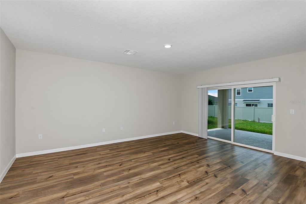 4385 Prairie Run Haines City, FL 33844 - Photo 10 of 25 an empty room with wooden floor and windows