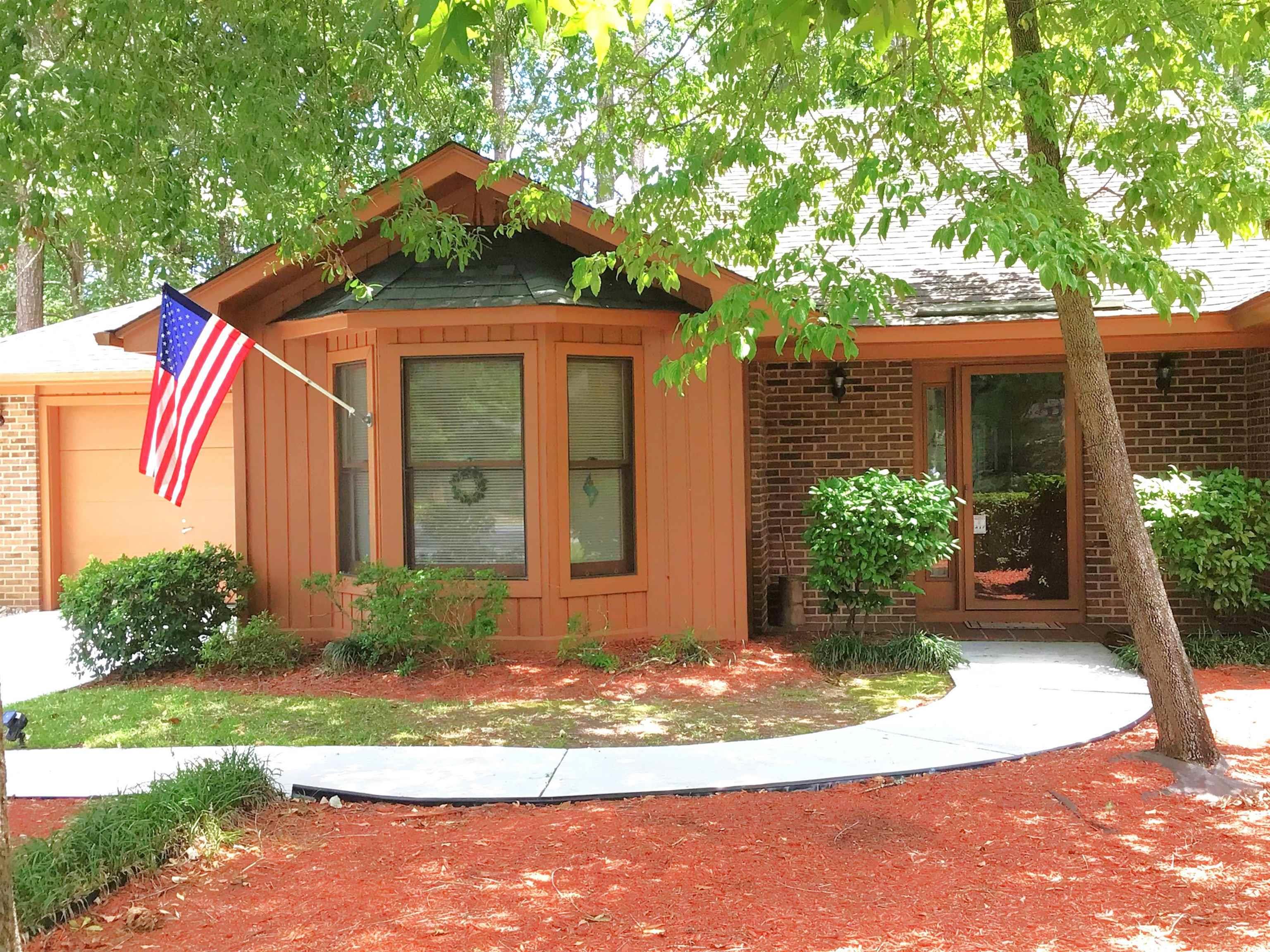View of front facade featuring brick siding and an attached garage