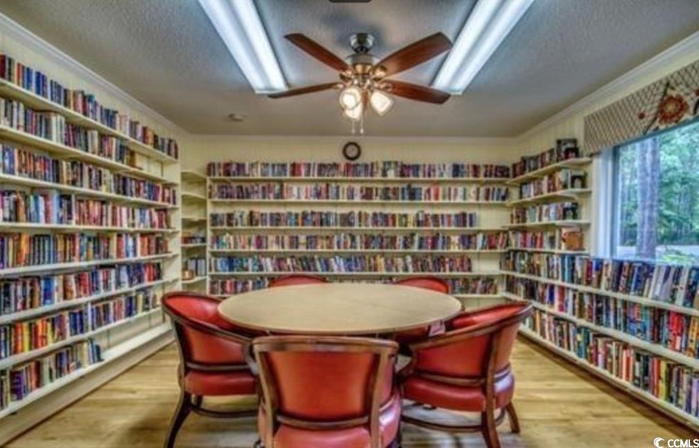 107 Myrtle Trace Drive Conway, SC 29526 - Photo 30 of 31 Sitting room with wall of books, a textured ceiling, wood finished floors, ceiling fan, and ornamental molding