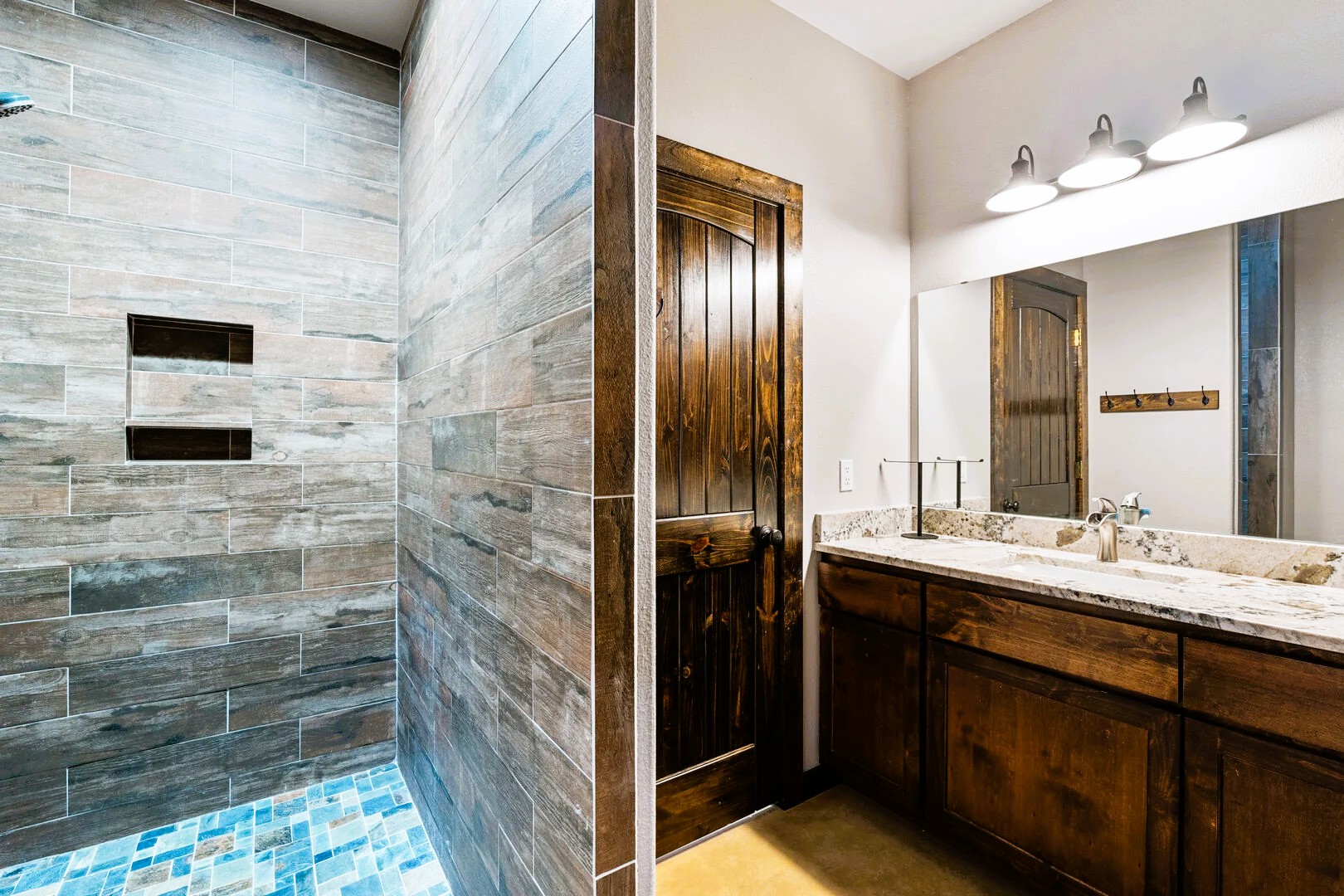 1718 Mountain Valley Road Concan, TX 78838 - Photo 23 of 40 Rich wood tones and tiled walls define this elegant restroom space.