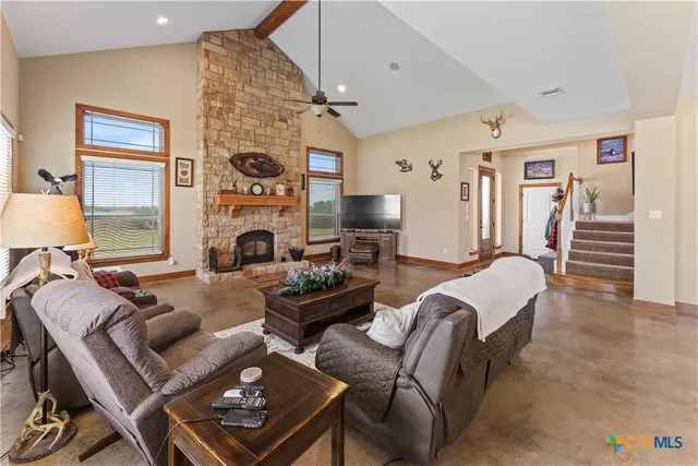 a living room with furniture a fireplace and a flat screen tv