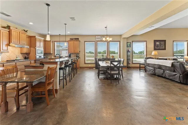 a large kitchen with lots of counter space dining table and chairs