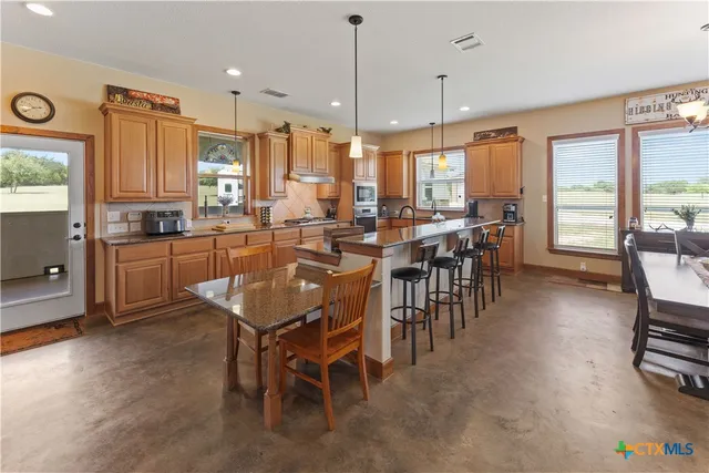 a dining table with chairs and large windows