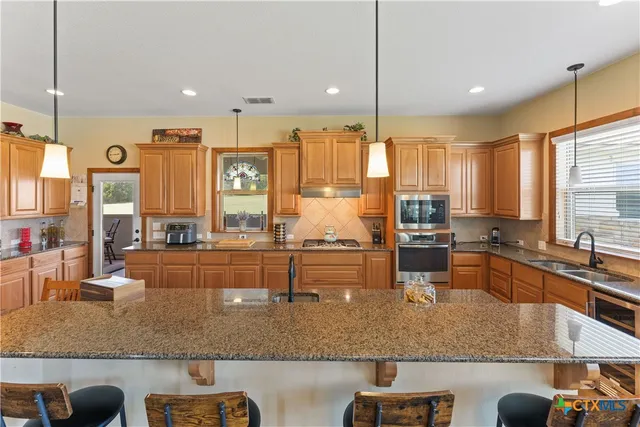a large kitchen with kitchen island granite countertop a large window