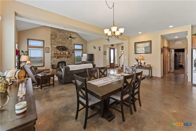 a view of a dining room and livingroom with furniture wooden floor a chandelier