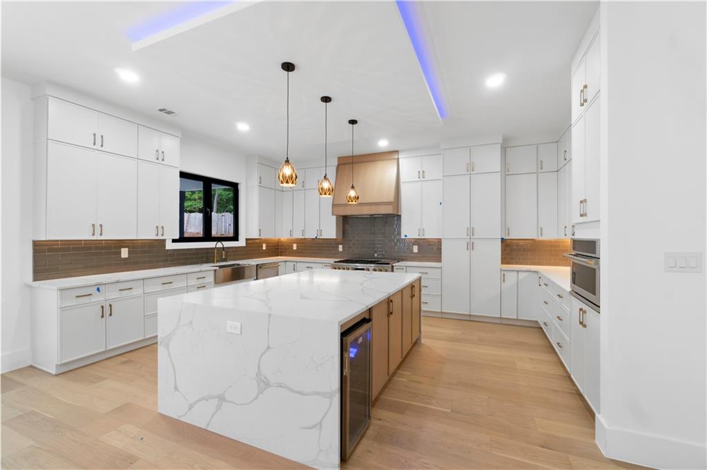 2701 Collins Hill Road Lawrenceville, GA 30043 - Photo 18 of 67 a large kitchen with stainless steel appliances kitchen island granite countertop a sink a stove and a refrigerator