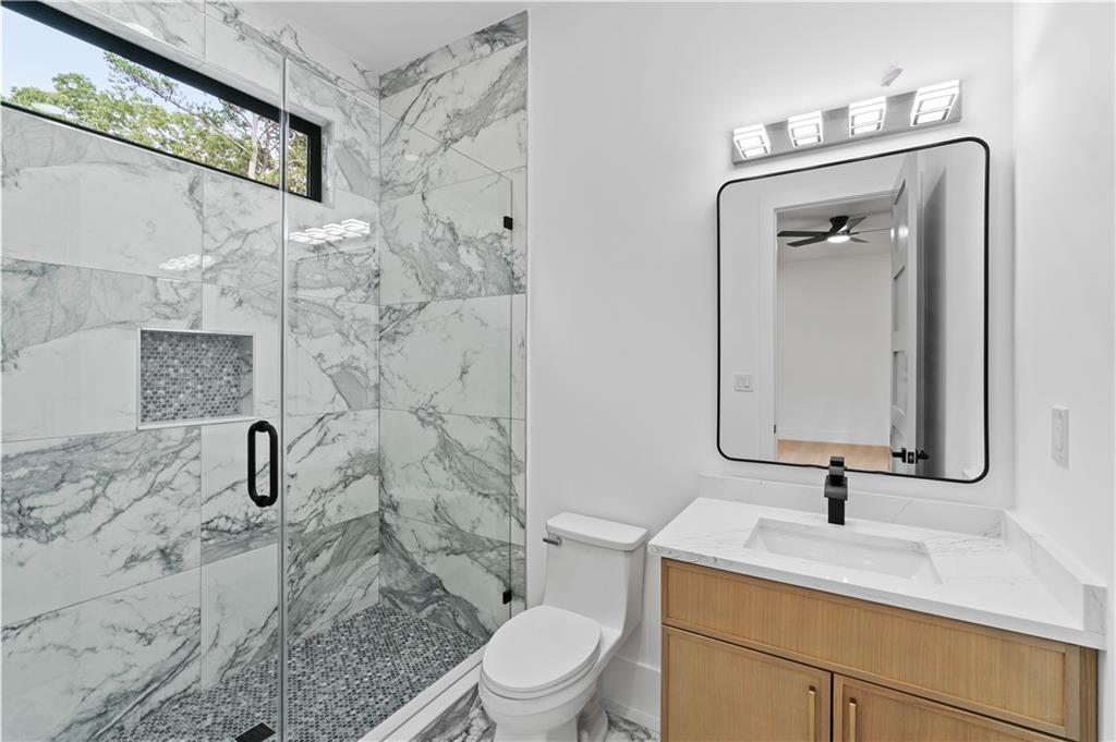2701 Collins Hill Road Lawrenceville, GA 30043 - Photo 42 of 67 a bathroom with a granite countertop sink a toilet and shower