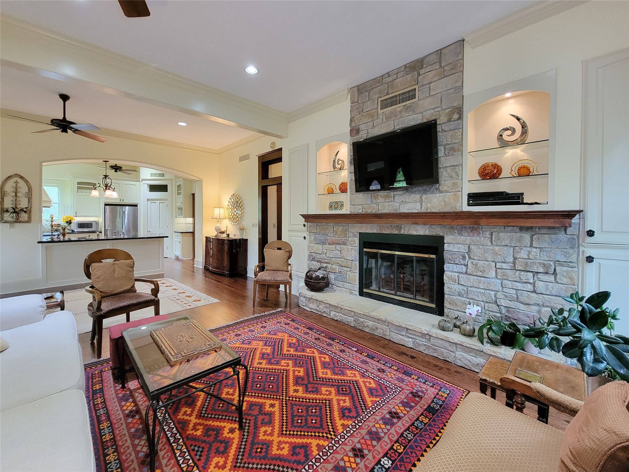 1406 Key Street Brenham, TX 77833 - Photo 13 of 50 This elegant fireplace features a stunning floor-to-ceiling stone surround and illuminated shelves, perfect for showcasing your art and valuables.