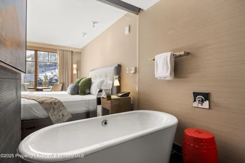 a bathroom with a tub sink and mirror