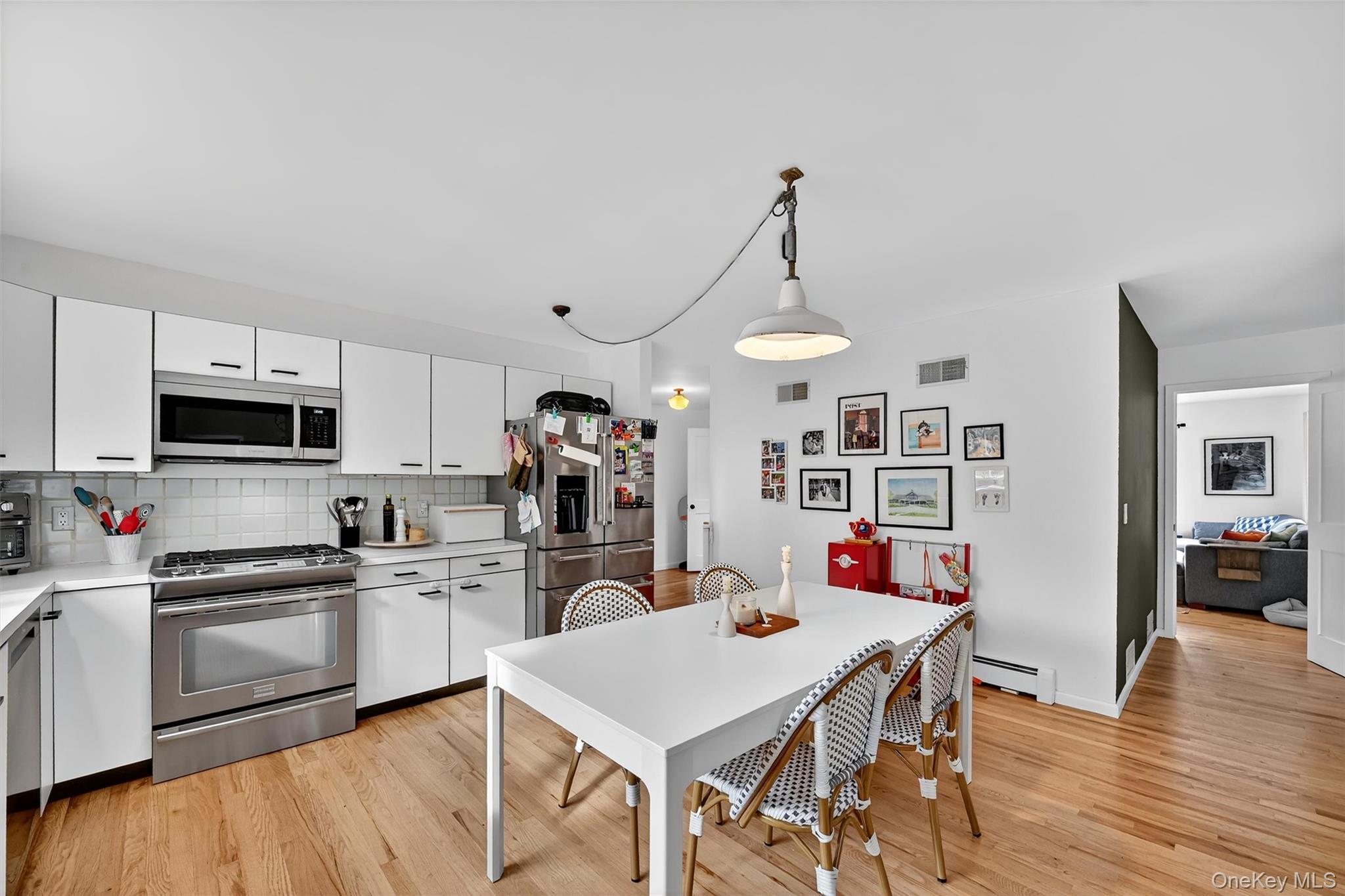 16 Oxford Springs Road Chester, NY 10918 - Photo 14 of 48 a kitchen with stainless steel appliances kitchen island granite countertop a sink dishwasher a stove a microwave oven a dining table and chairs with wooden floor