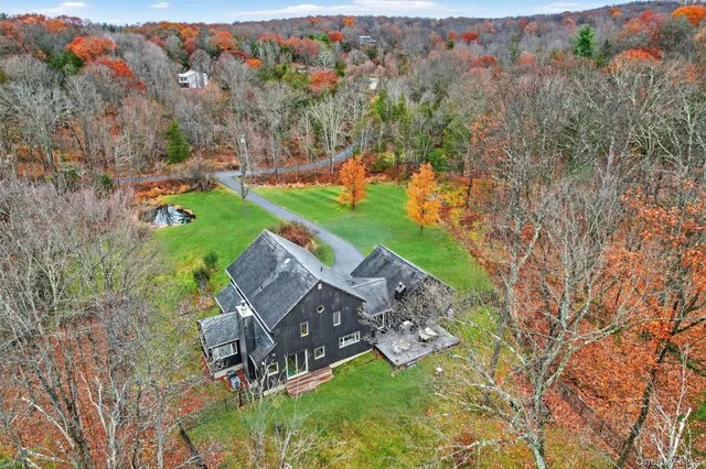 a view of a house with a big yard and large trees