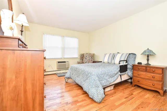 a dining room with furniture a large window and wooden floor