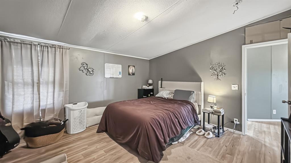 185 Private Road 4437 Rhome, TX 76078 - Photo 9 of 28 Interior room featuring wood-finish flooring and neutral gray walls