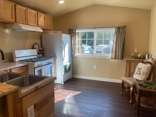a kitchen with granite countertop a sink cabinets and stainless steel appliances