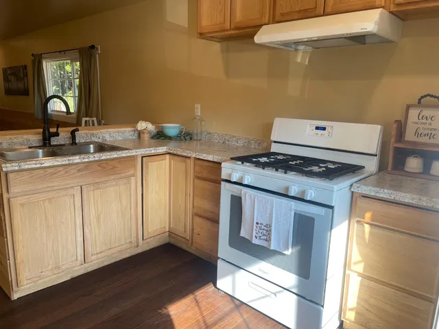 a hallway with wooden floor and staircase