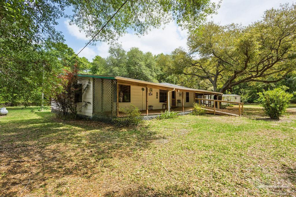 8938 Pioneer Road Holt, FL 32564 - Photo 38 of 44 a view of a house with backyard and trees