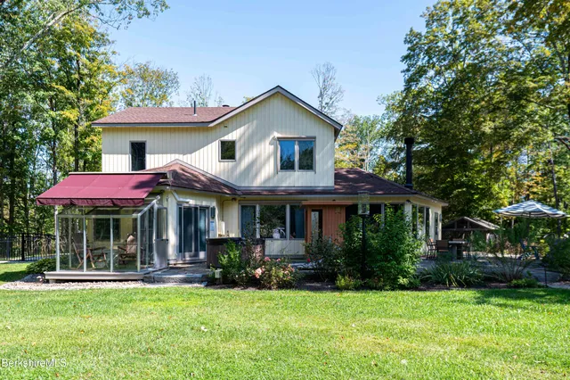 a front view of a house with a yard and trees