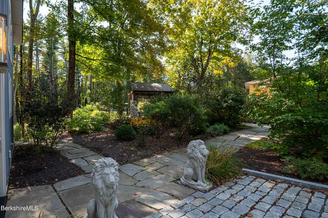 a view of a patio with table and chairs potted plants and large tree