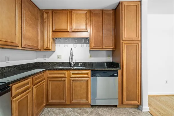a kitchen with granite countertop wooden cabinets and white appliances