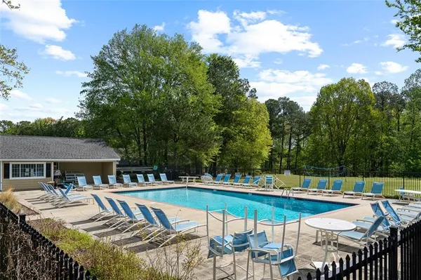 a view of a house with swimming pool and sitting area