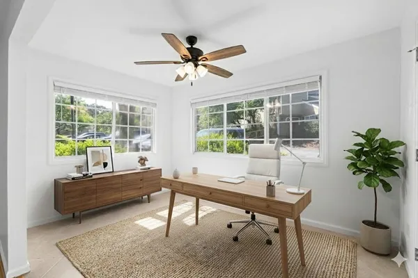 a living room with furniture a window and a potted plant