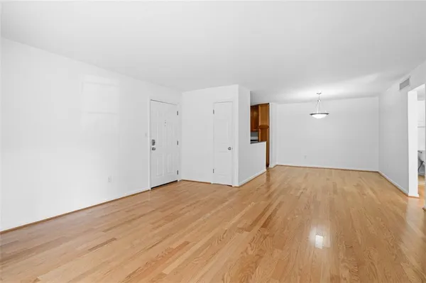 a view of empty room with wooden floor
