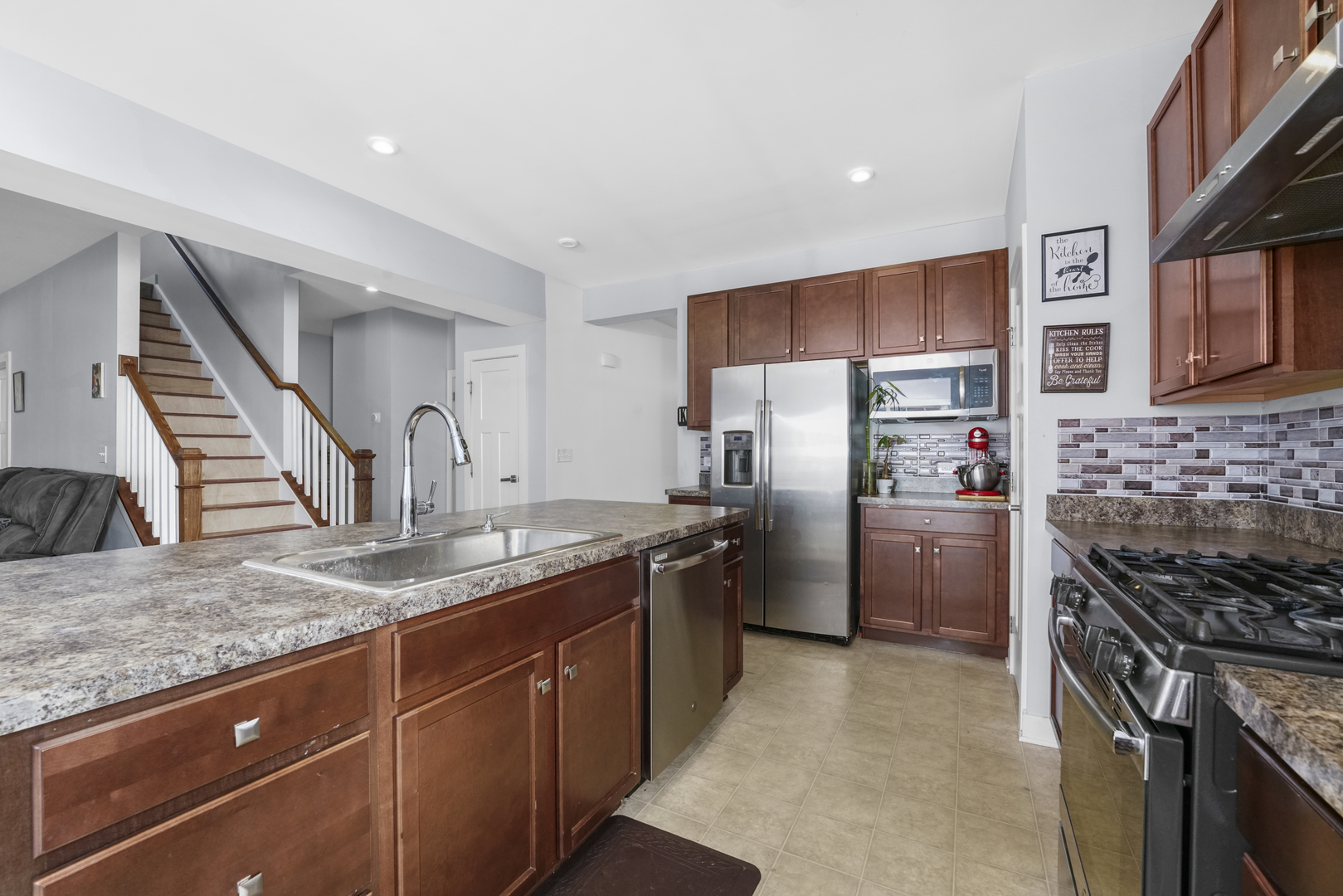 3413 Forestview Drive Joliet, IL 60431 - Photo 6 of 32 a kitchen with stainless steel appliances granite countertop a stove a sink and a refrigerator
