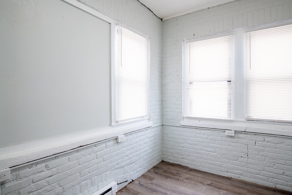 69 Winter Street Springfield, MA 01105 - Photo 17 of 36 a view of an empty room with wooden floor and a window