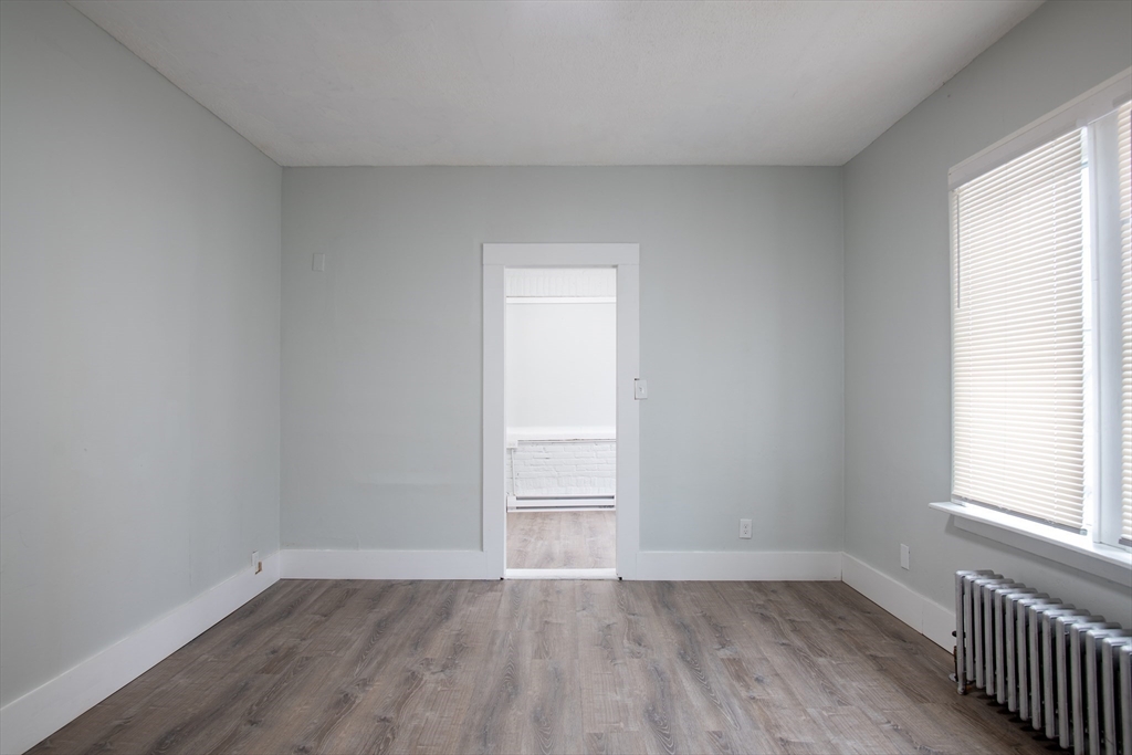 69 Winter Street Springfield, MA 01105 - Photo 19 of 36 an empty room with wooden floor and window